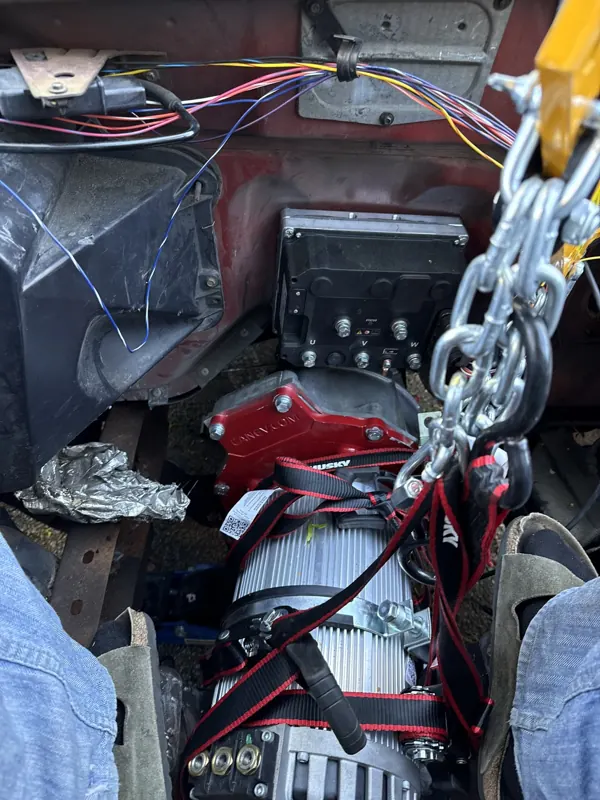 Hyper9 electric motor and X1 inverter being lowered into the Ranger's engine bay on a chain hoist