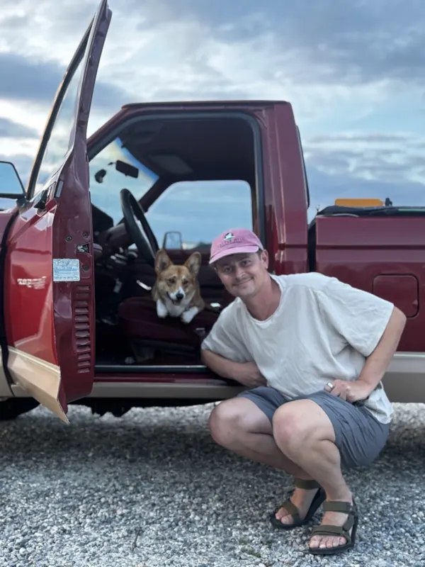 The finished electric 1986 Ford Ranger with its builder and a corgi in the cab